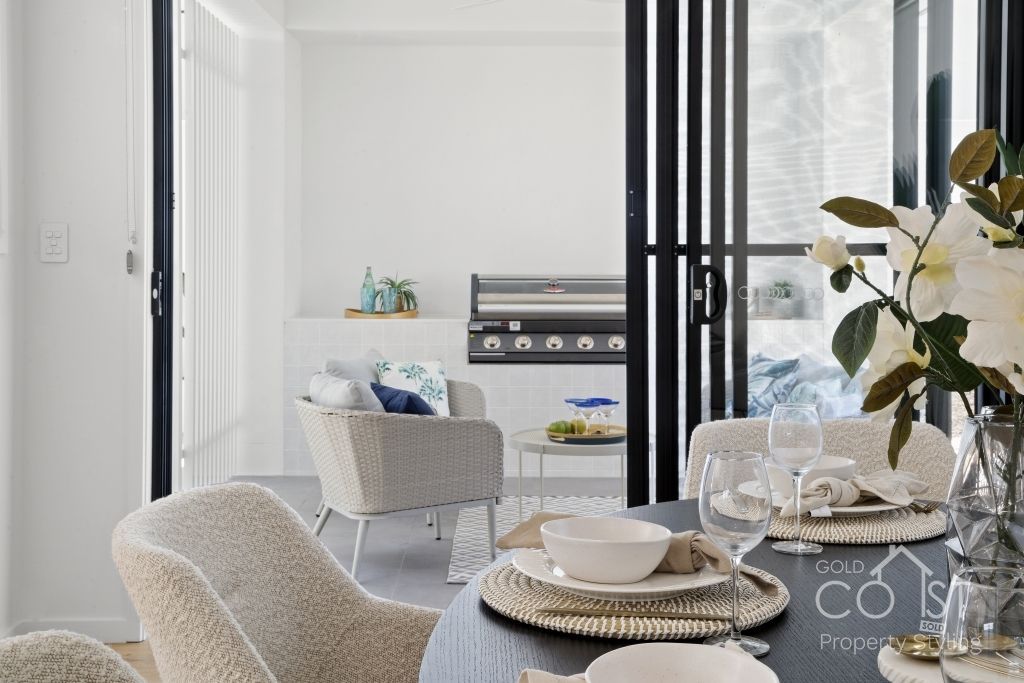 A dining room with a table and chairs and a sliding glass door.