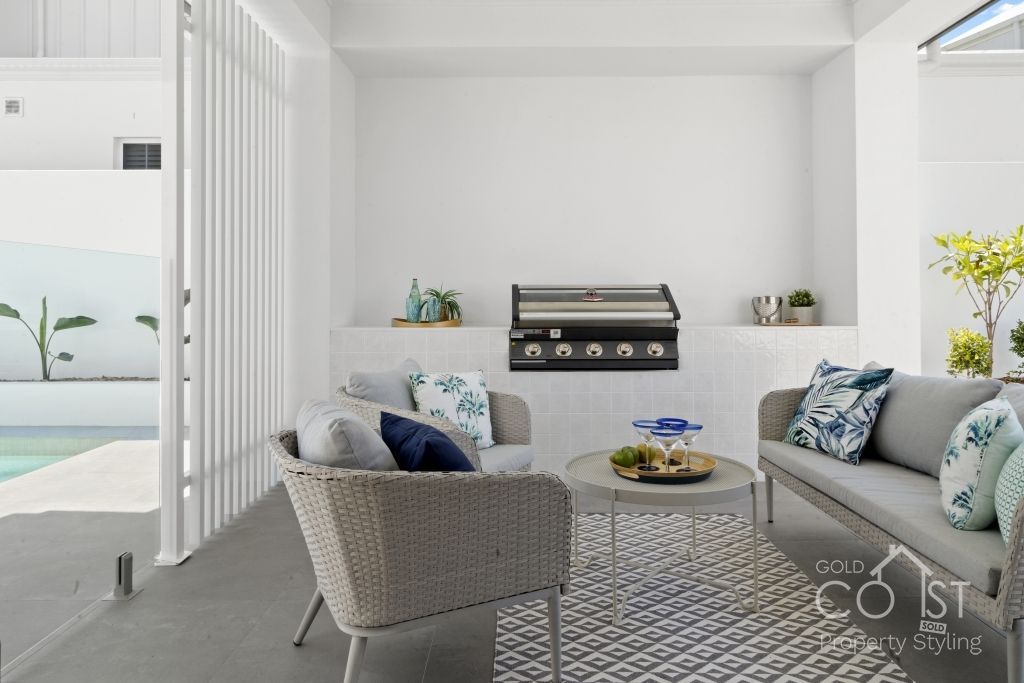 A living room with a couch , chair , table and grill.