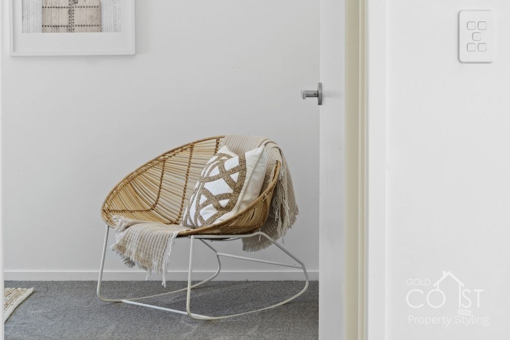 A rocking chair is sitting in a room next to a door.
