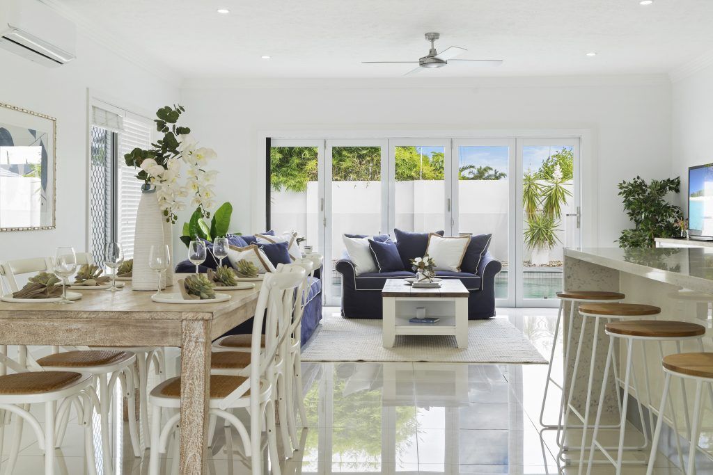 A living room with a dining table and chairs and a ceiling fan.