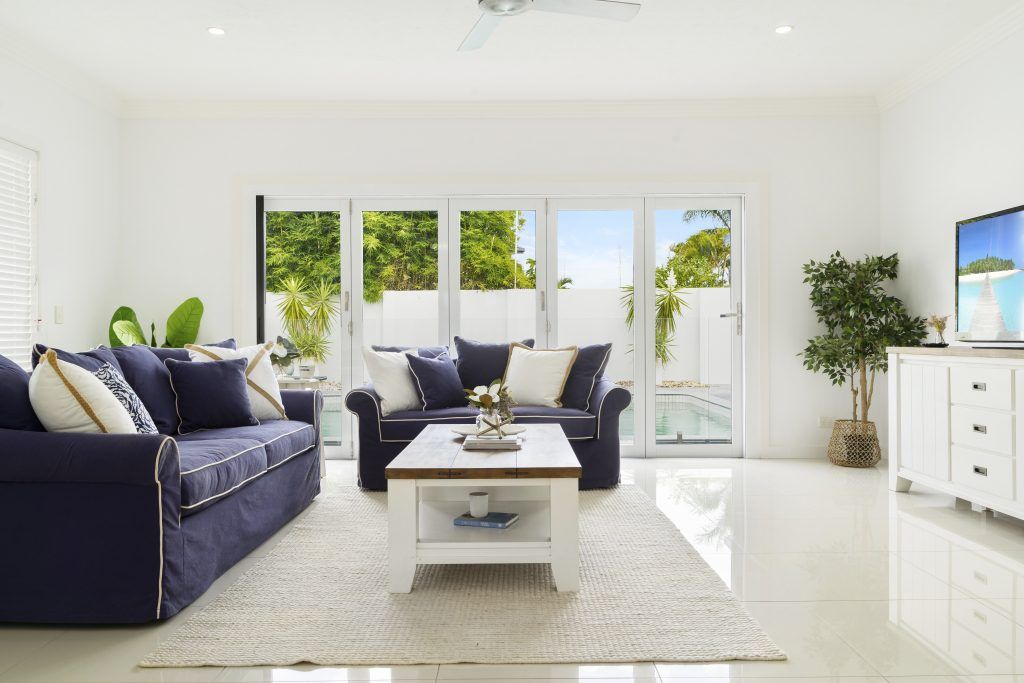 A living room with a blue couch and a white coffee table