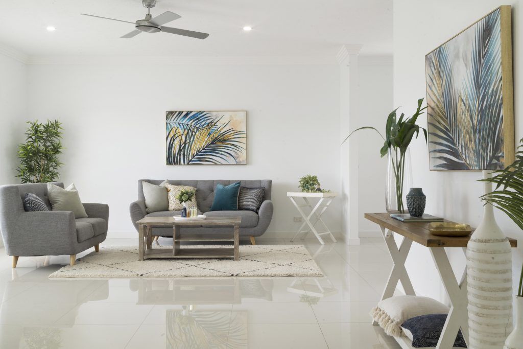 A living room with a couch , chairs , table and a ceiling fan.