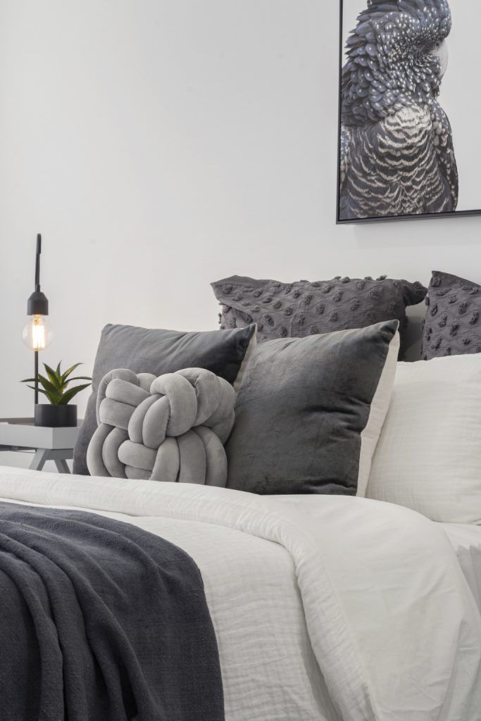 There is a picture of a bird on the wall above the bed.