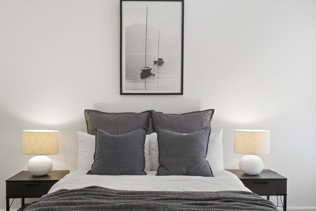 There is a picture on the wall above the bed in the bedroom.