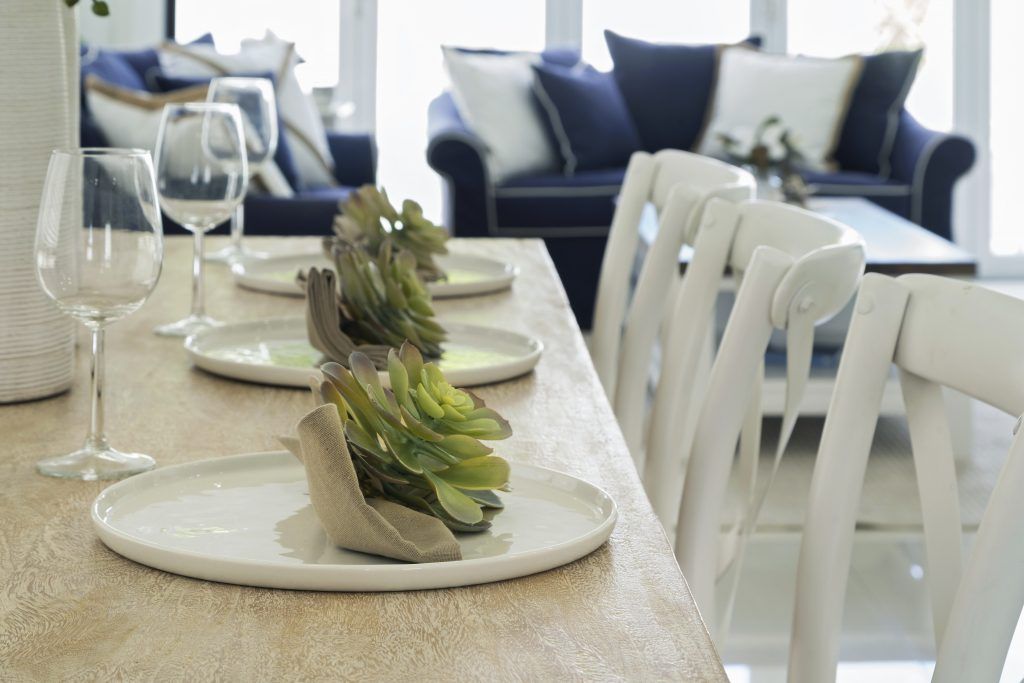 A table with plates and wine glasses on it in a living room.