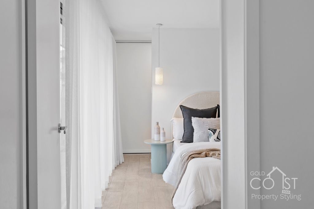 A bedroom with a bed , nightstand , and curtains.