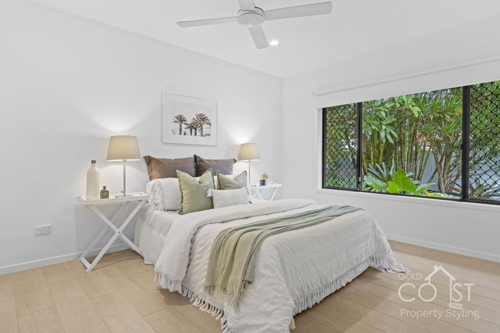 A bedroom with a large bed and a ceiling fan.