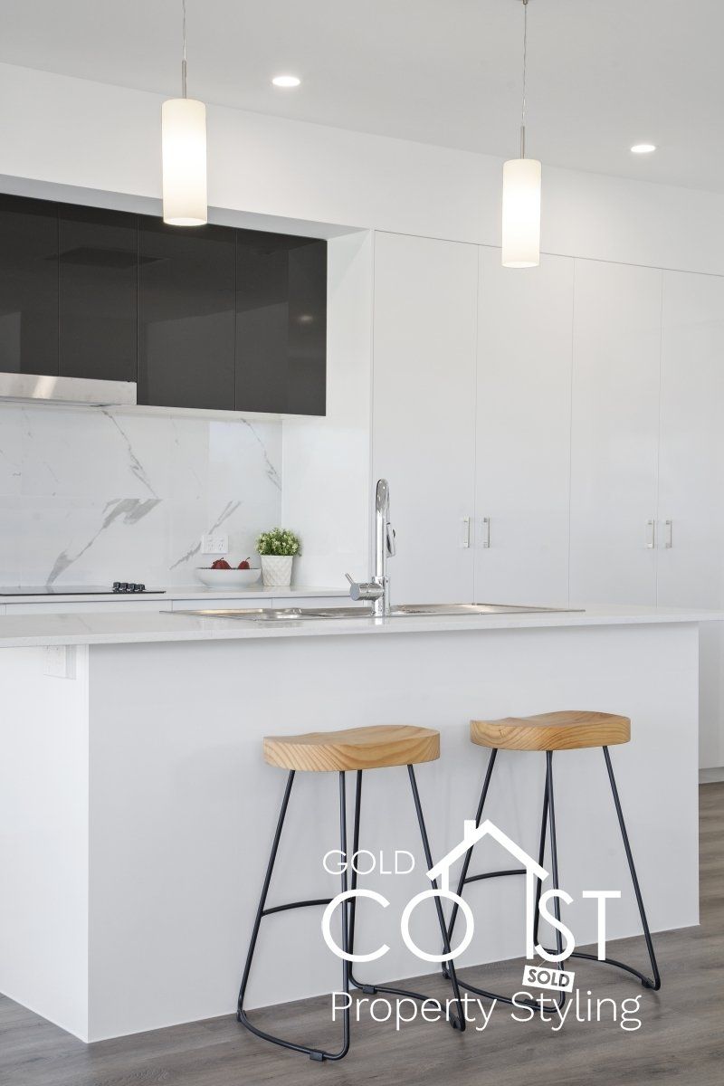 A kitchen with a large island and two stools