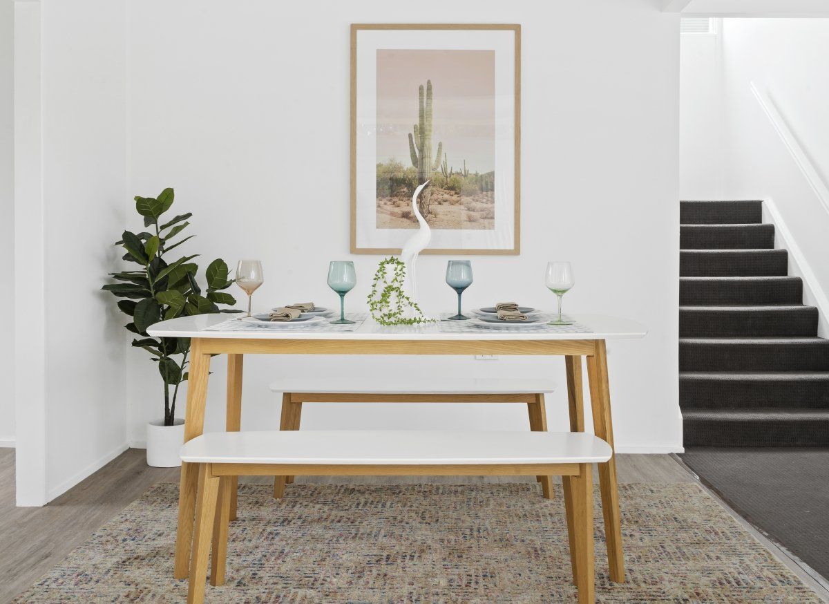 There is a picture of a cactus on the wall above the table.