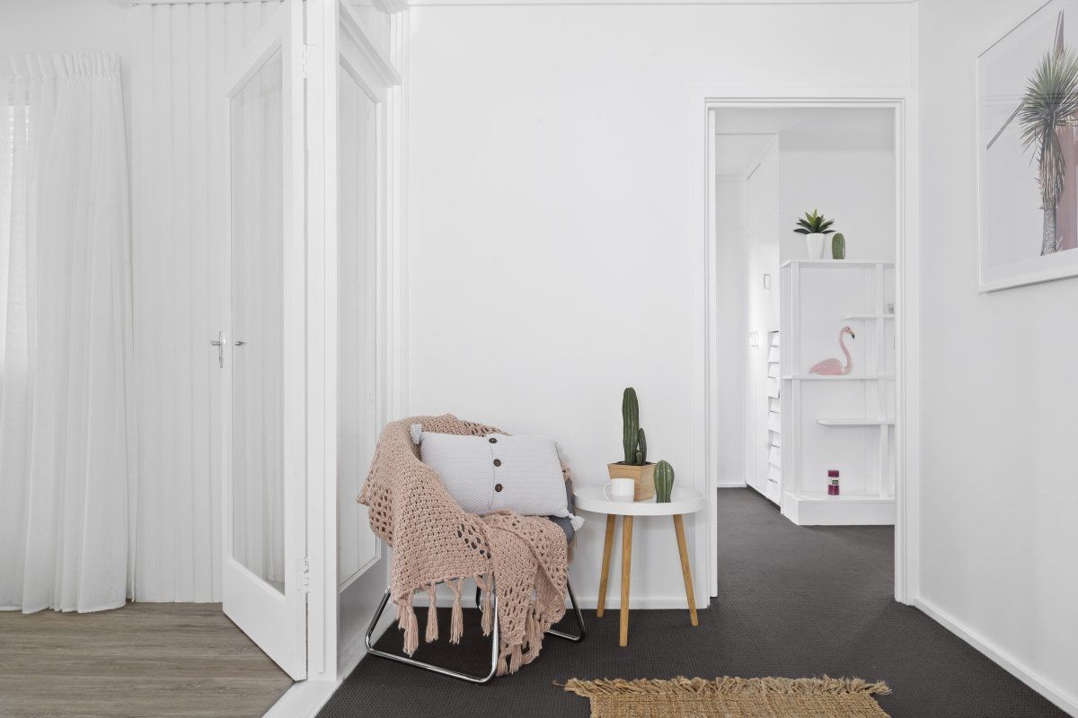 There is a chair and a table in the hallway.