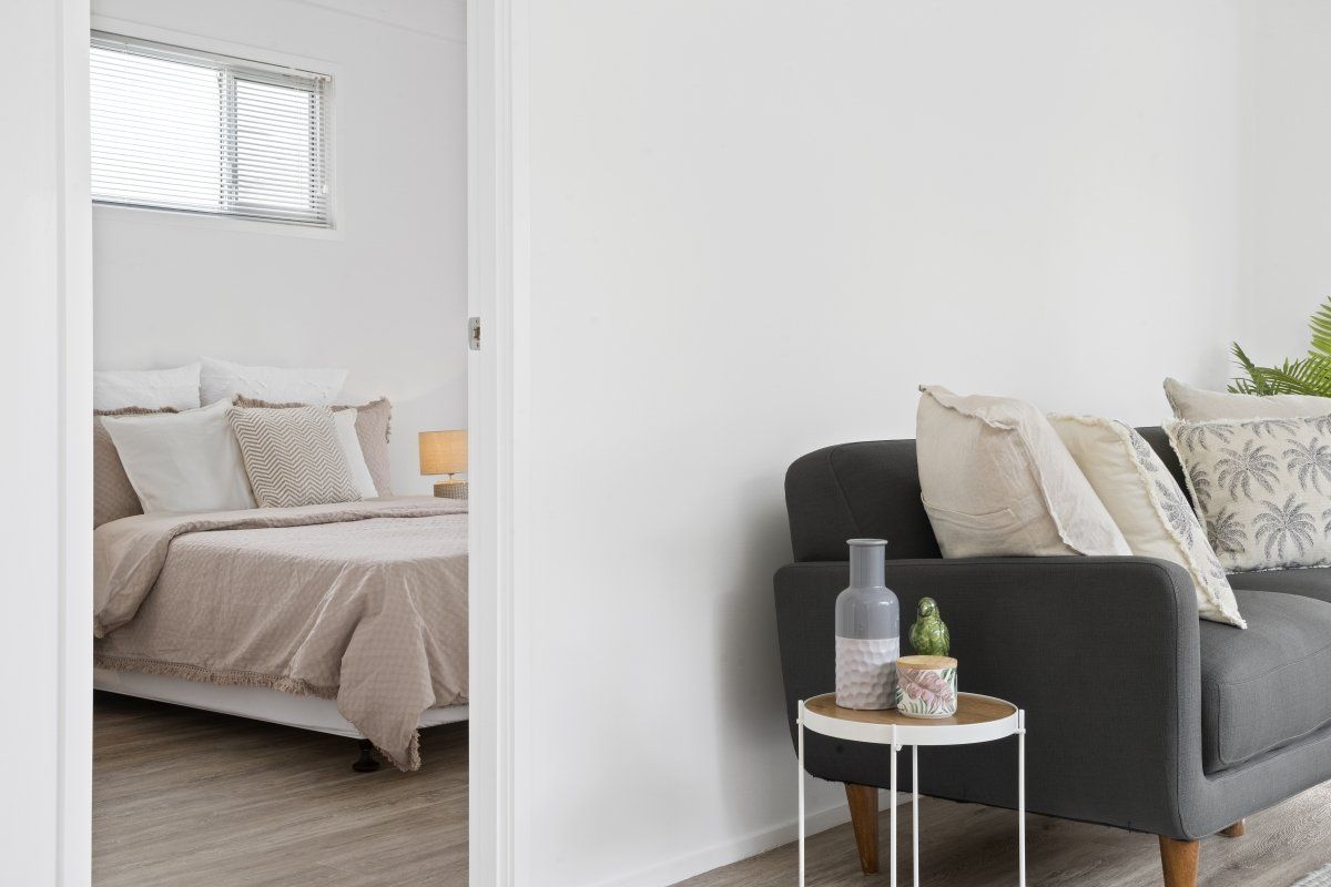 A bedroom with a couch and a bed next to a living room.