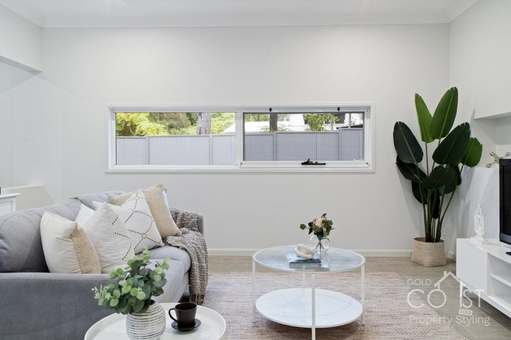 A living room with a couch , coffee table , and television.