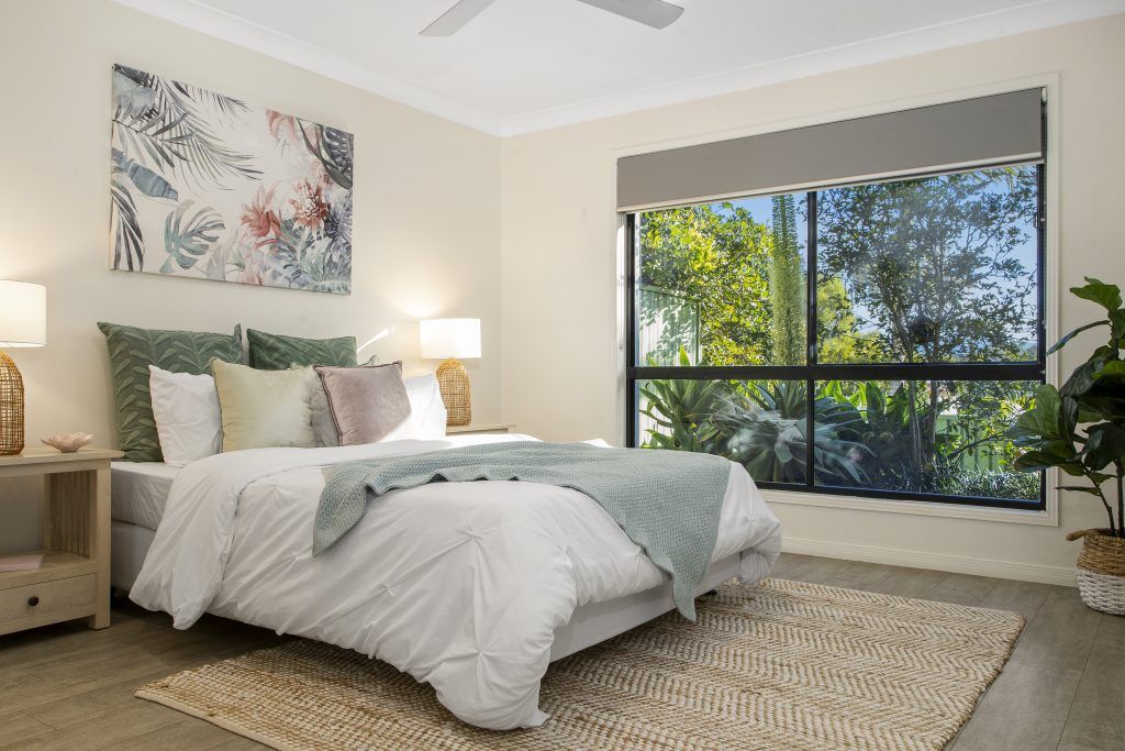 A bedroom with a large bed and a ceiling fan.