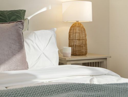 There is a lamp on the nightstand next to the bed.