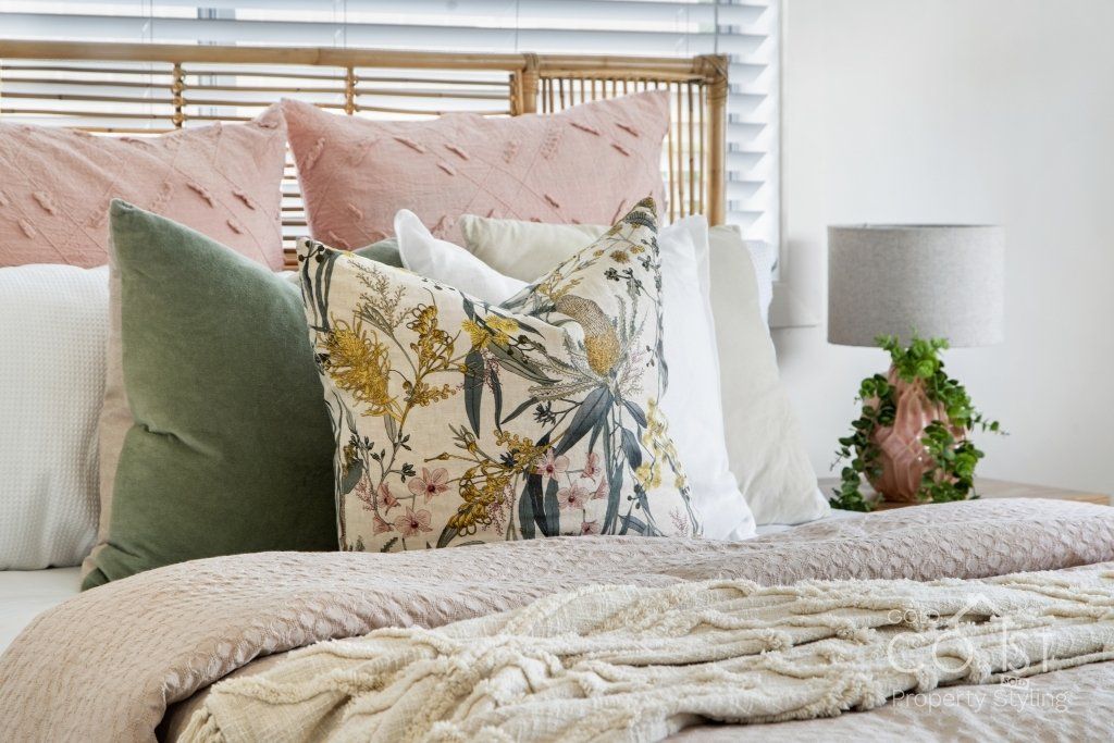 A bed with a lot of pillows on it in a bedroom.
