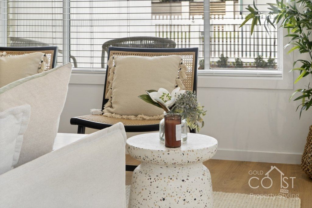 A living room with a couch , chair , table and window.