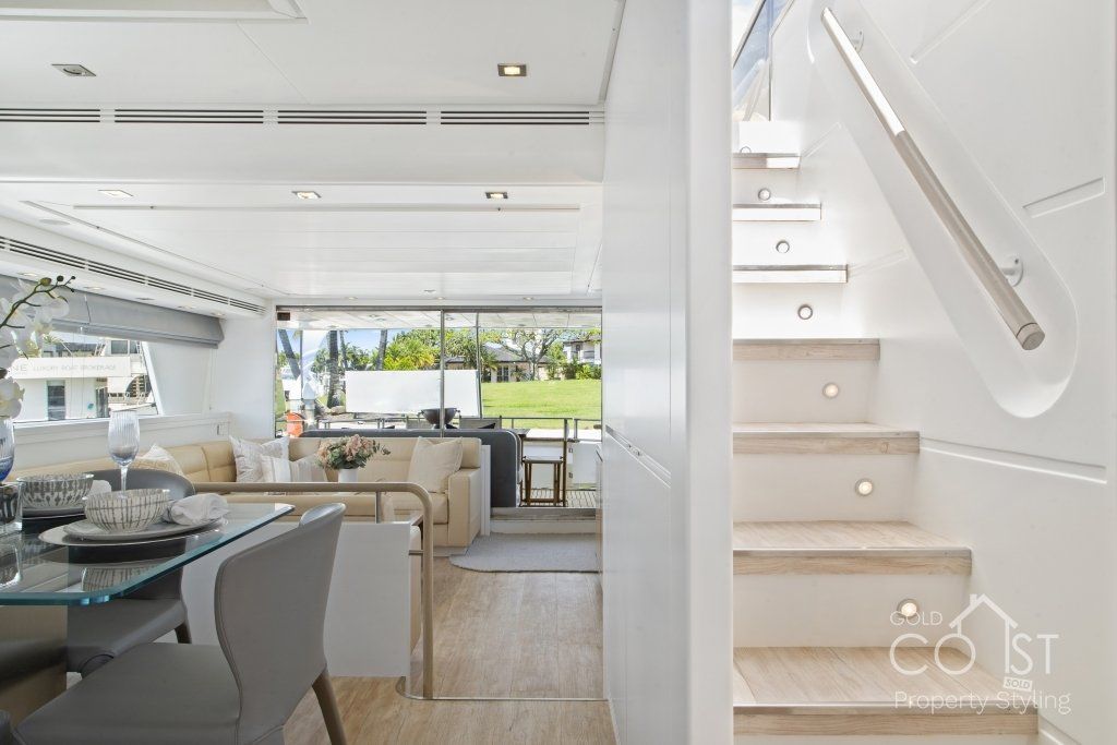 A living room with a table and chairs and stairs leading up to the second floor.