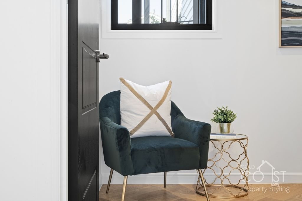 A chair with a pillow on it is sitting next to a table in a room.