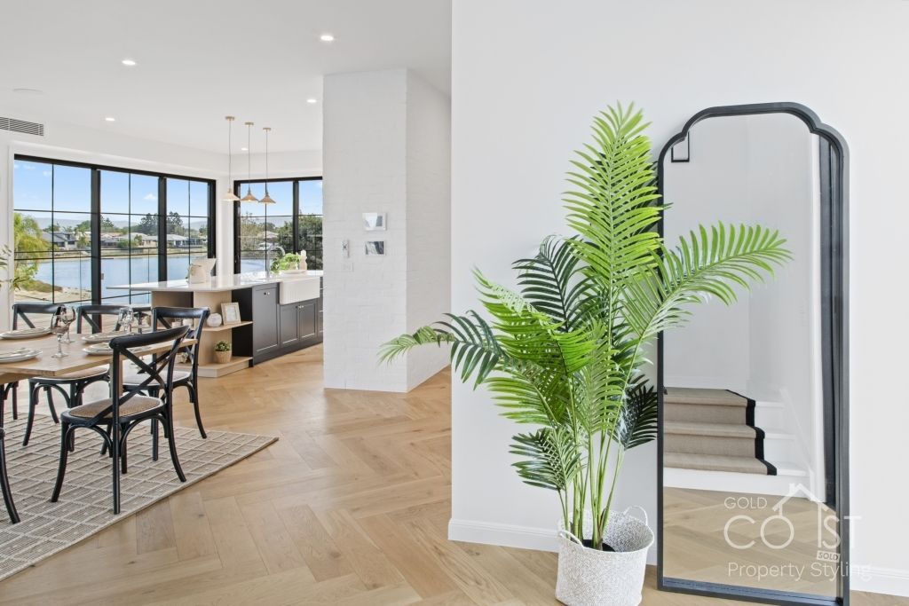 A living room with a large mirror and a potted plant.