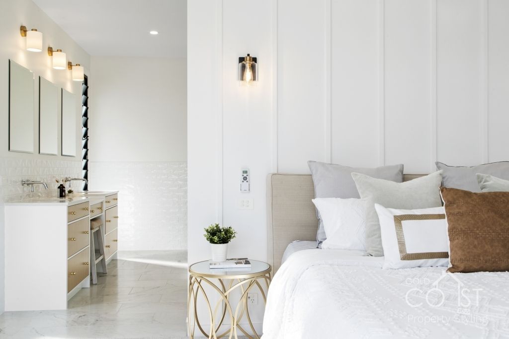 A bedroom with a bed and a bathroom in the background