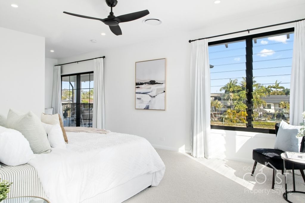 A bedroom with a large bed and a ceiling fan