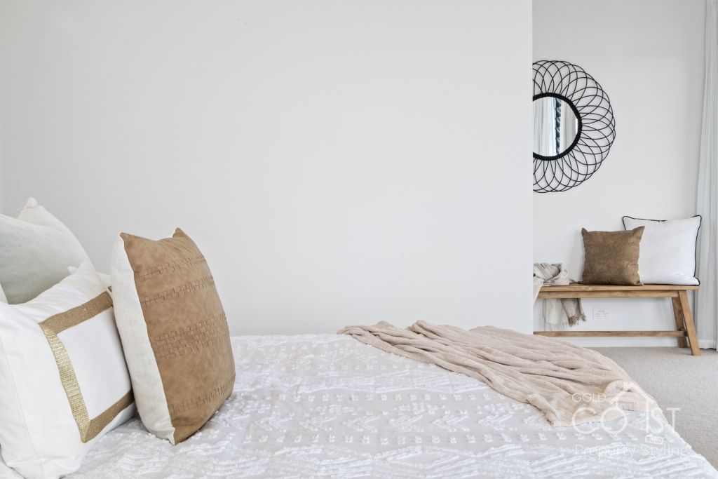 There is a mirror on the wall above the bed in the bedroom.