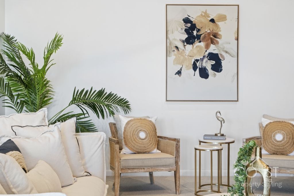 A living room filled with furniture and a painting on the wall.