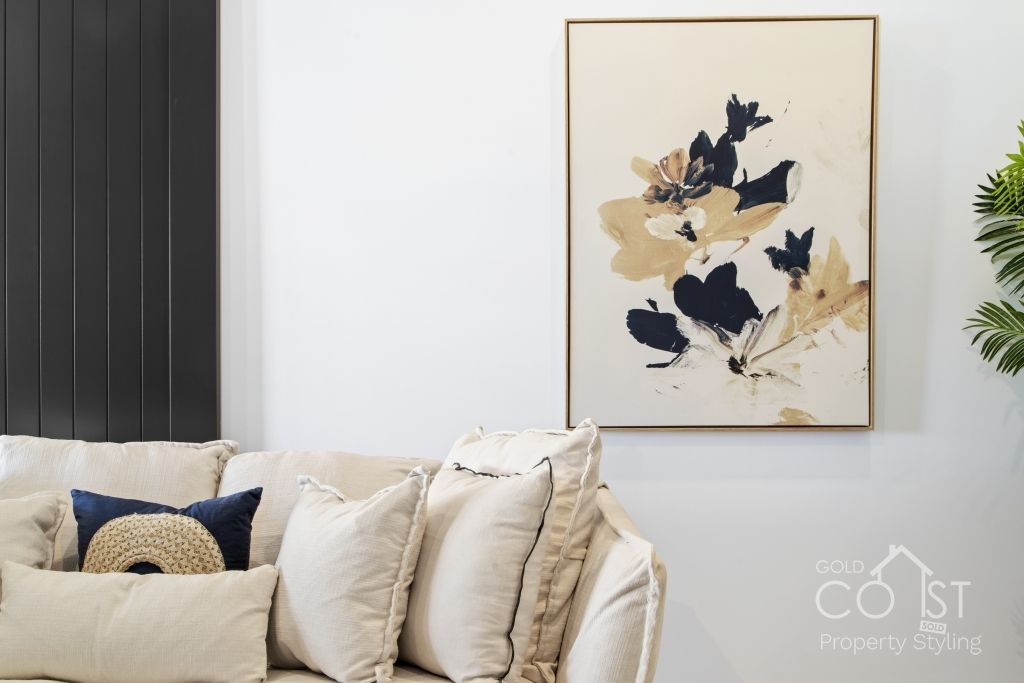 A living room with a couch and a painting on the wall