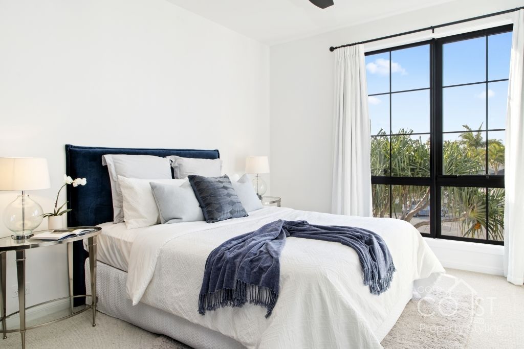 A bedroom with a large bed and a large window.