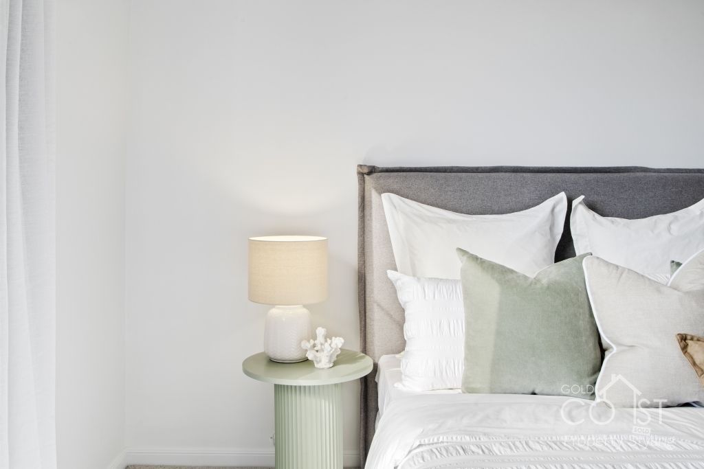 A bedroom with a bed , nightstand and lamp.