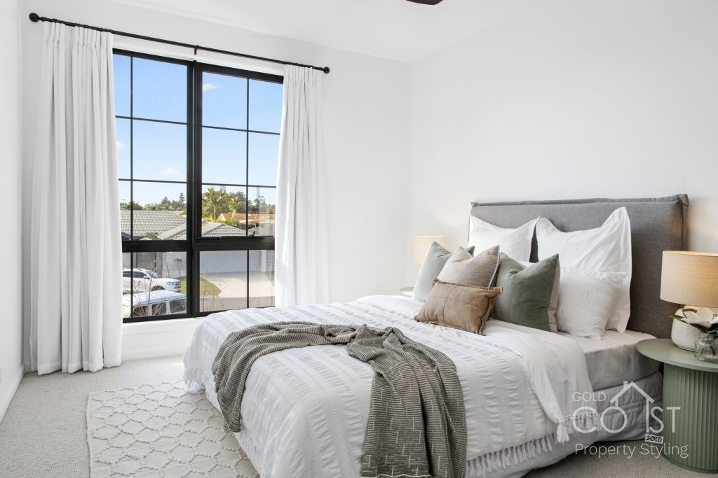 A bedroom with a large bed and a large window.