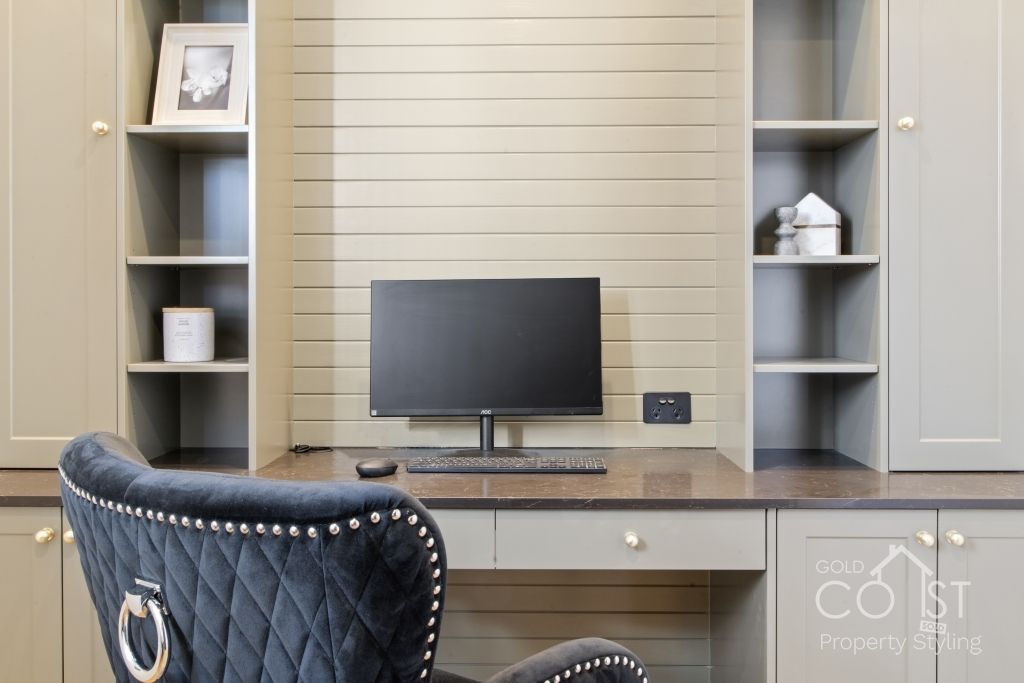 A chair is sitting in front of a desk with a computer on it.