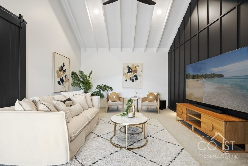 A living room with a couch , chairs , a coffee table and a flat screen tv.