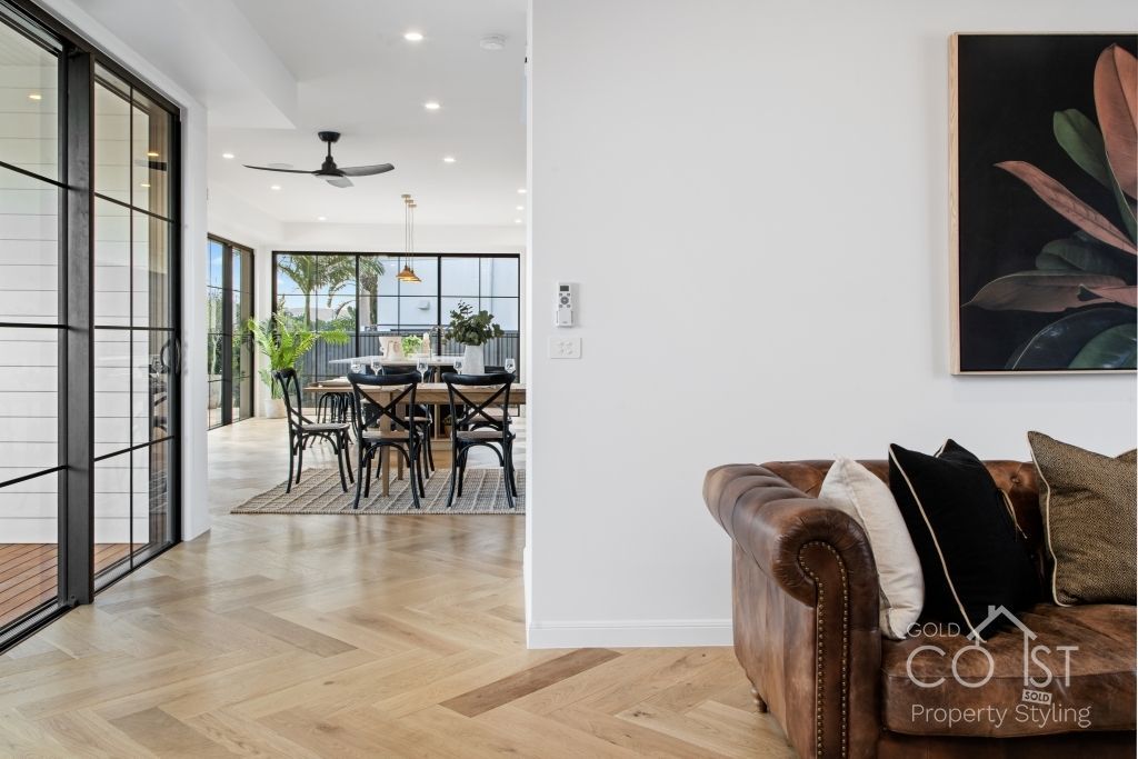 A living room with a couch and a painting on the wall.