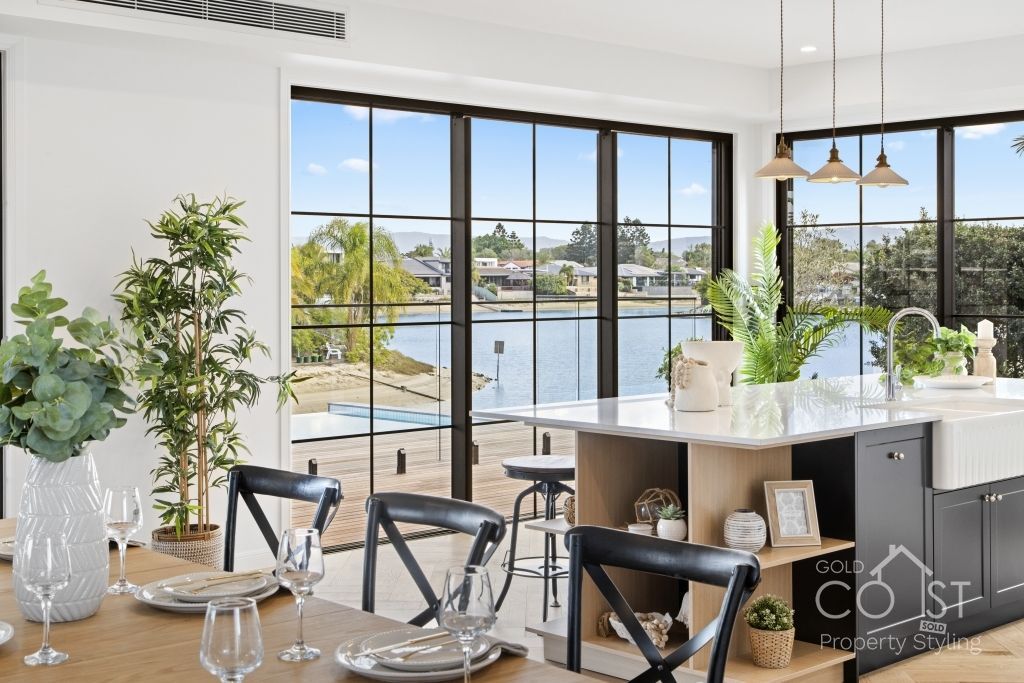 A dining room with a table and chairs and a view of a lake.