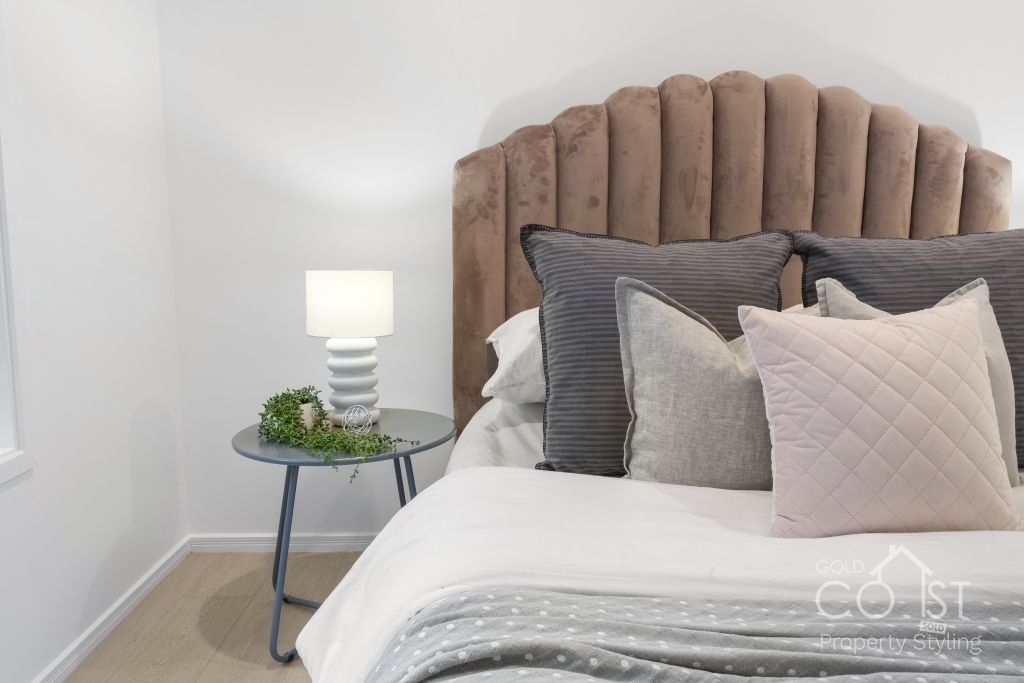 A bedroom with a bed , nightstand and lamp