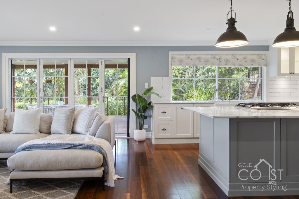 A living room with a couch and a kitchen with a large island.