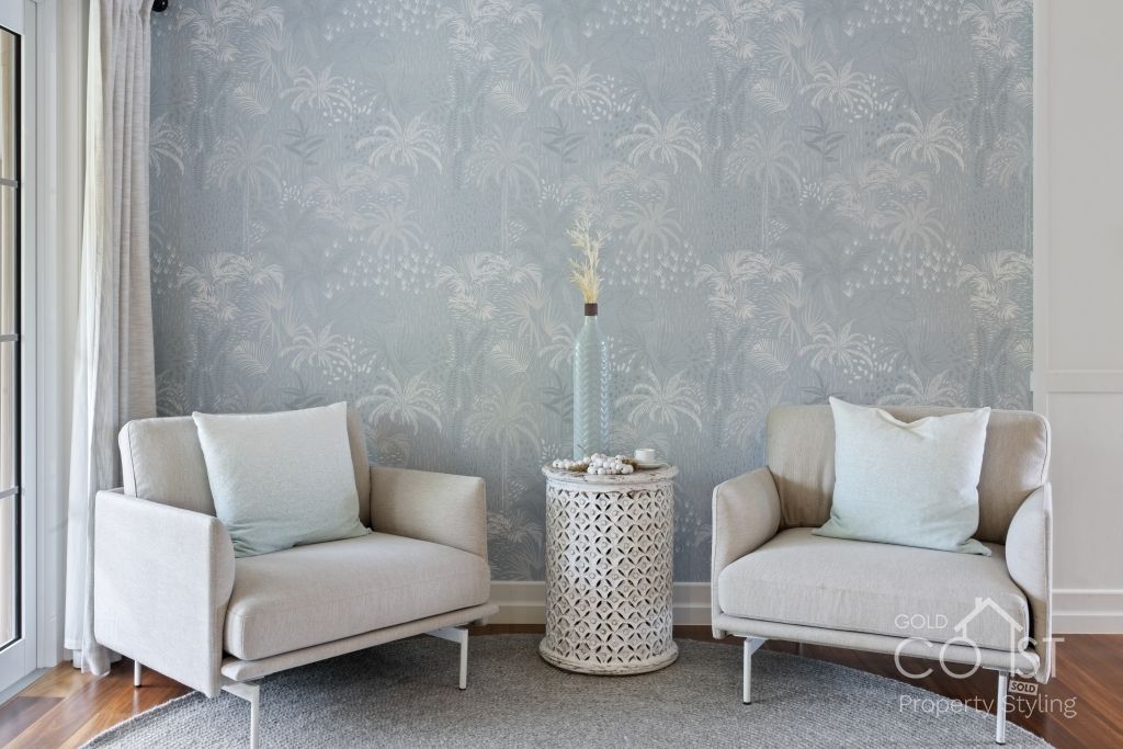 A living room with two white chairs and a table.