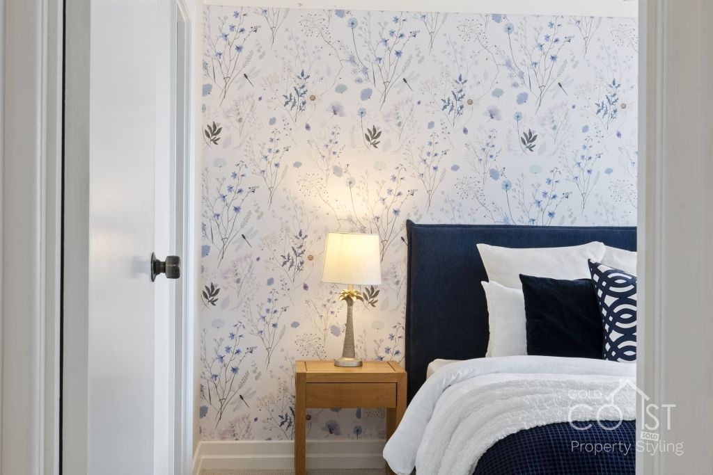 A bedroom with a bed , nightstand and lamp