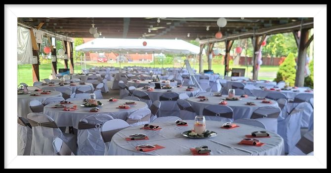 A large room with tables and chairs set up for a wedding reception under a tent.