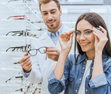 A man and a woman are trying on glasses in an optical shop.