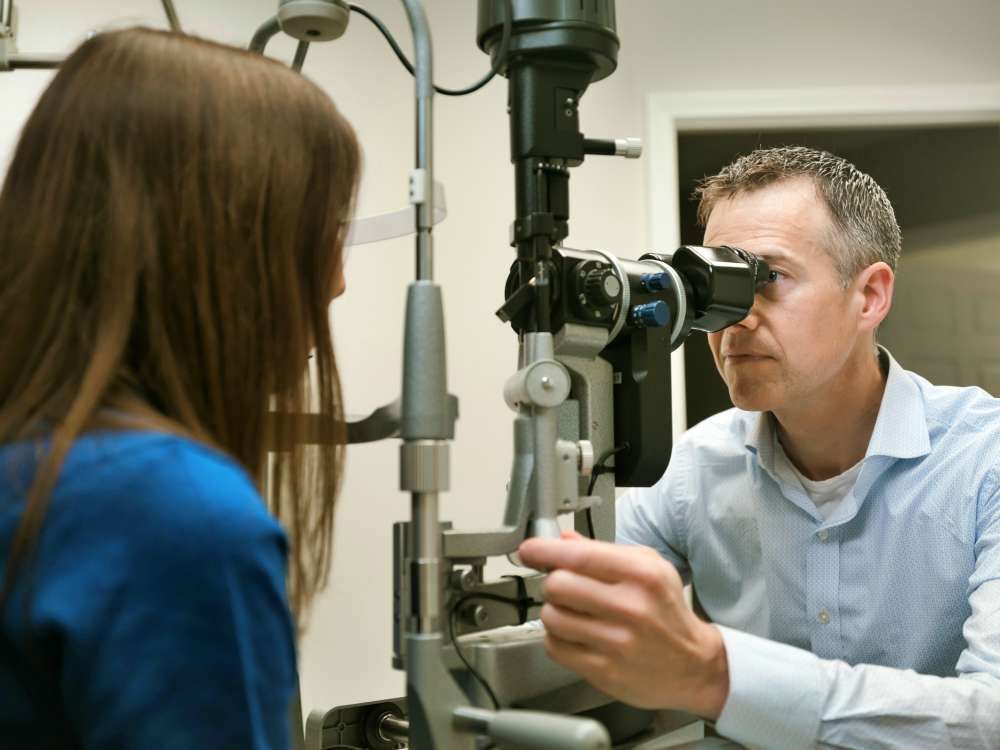 A woman is getting her eyes examined by an ophthalmologist