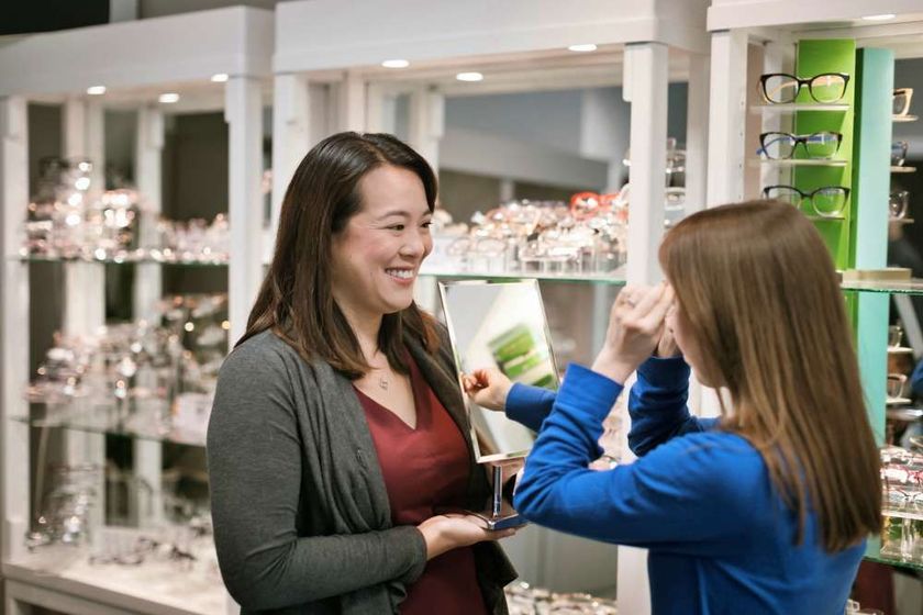 Two women are standing next to each other in an optical shop.