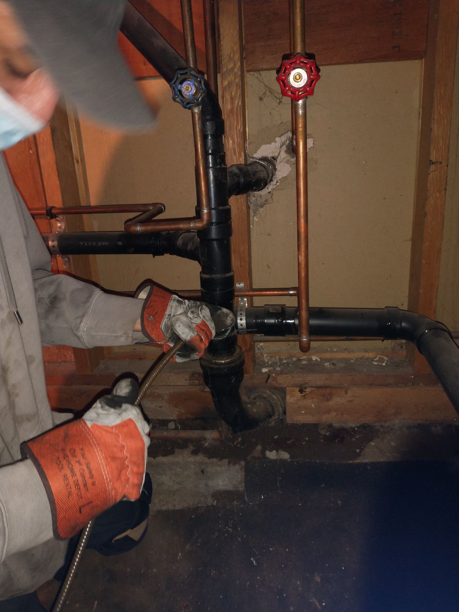 A man is working on a pipe with a hose.