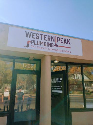 The front of a building with a sign that says western peak plumbing.