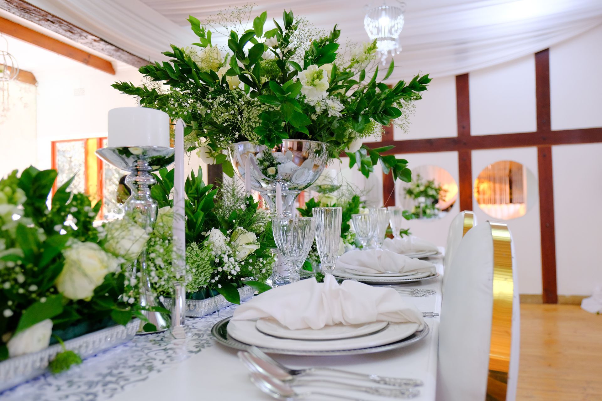 A table set for a wedding reception with plates , silverware , candles and flowers.