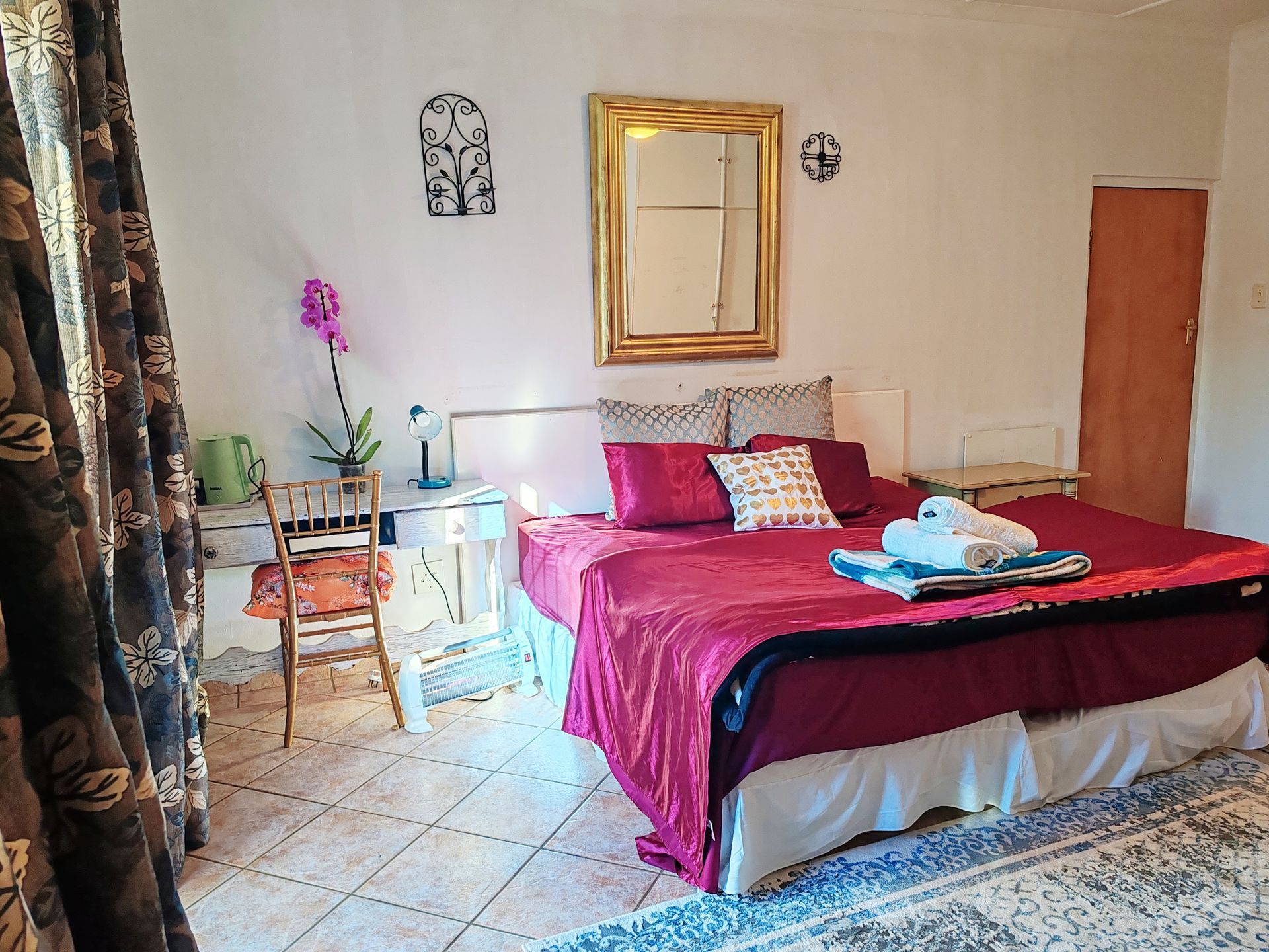 A bedroom with a large bed and a mirror on the wall.