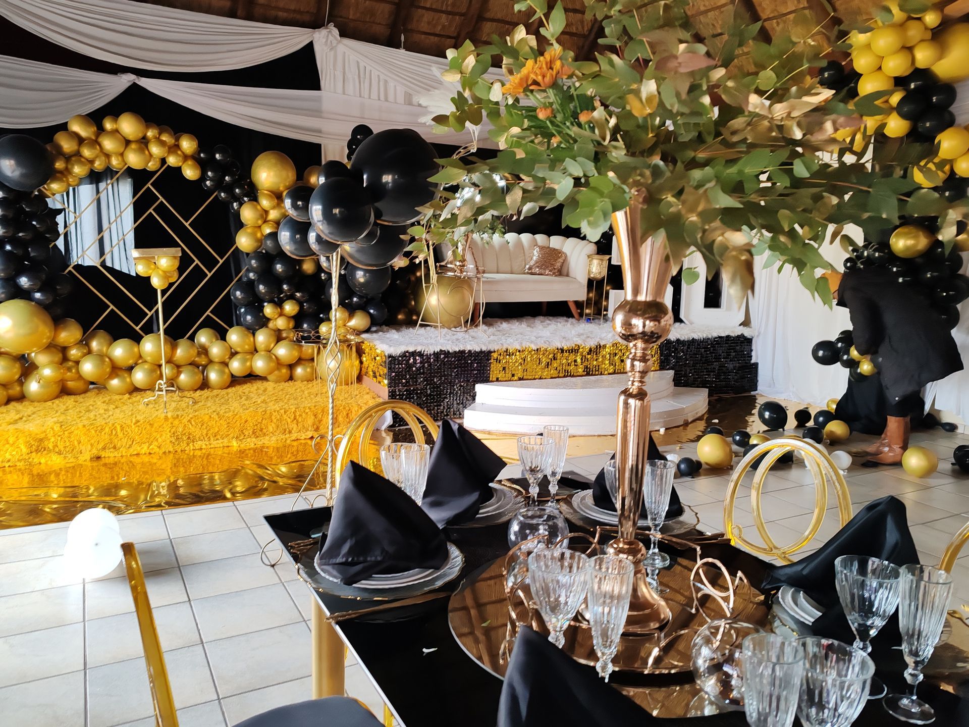 A table set for a party with a vase of flowers on it.