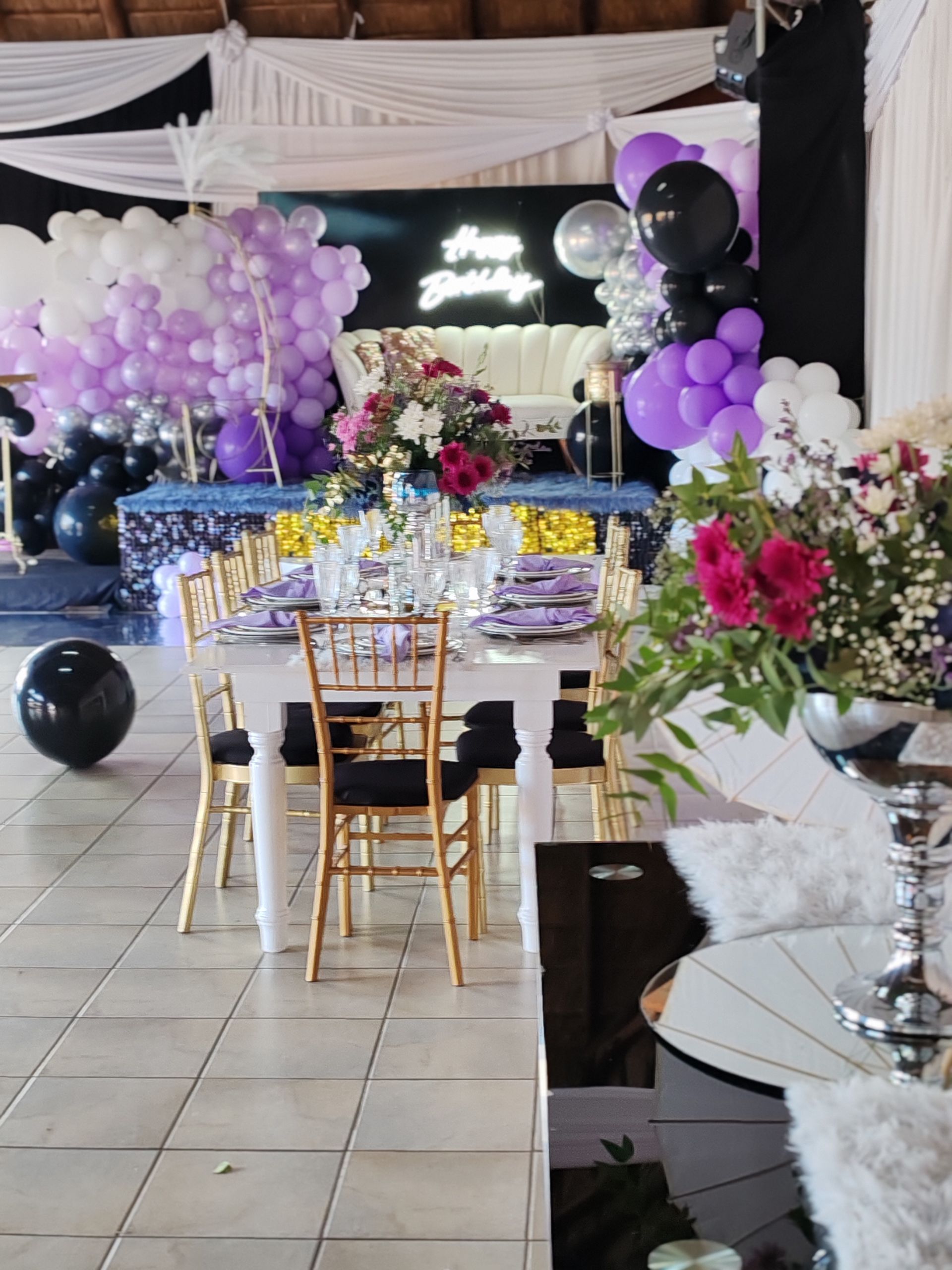 A room with tables and chairs decorated with balloons and flowers