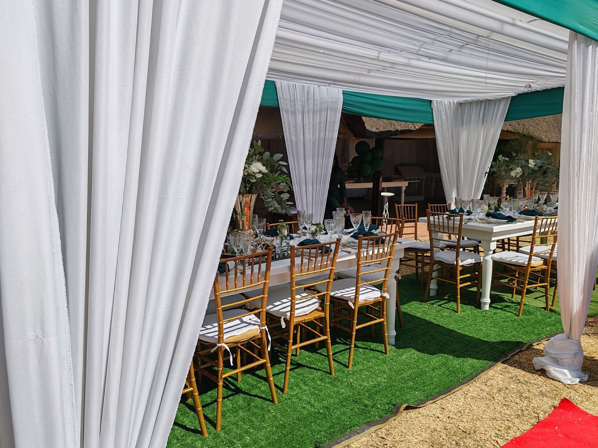A tent with tables and chairs set up for a wedding reception.